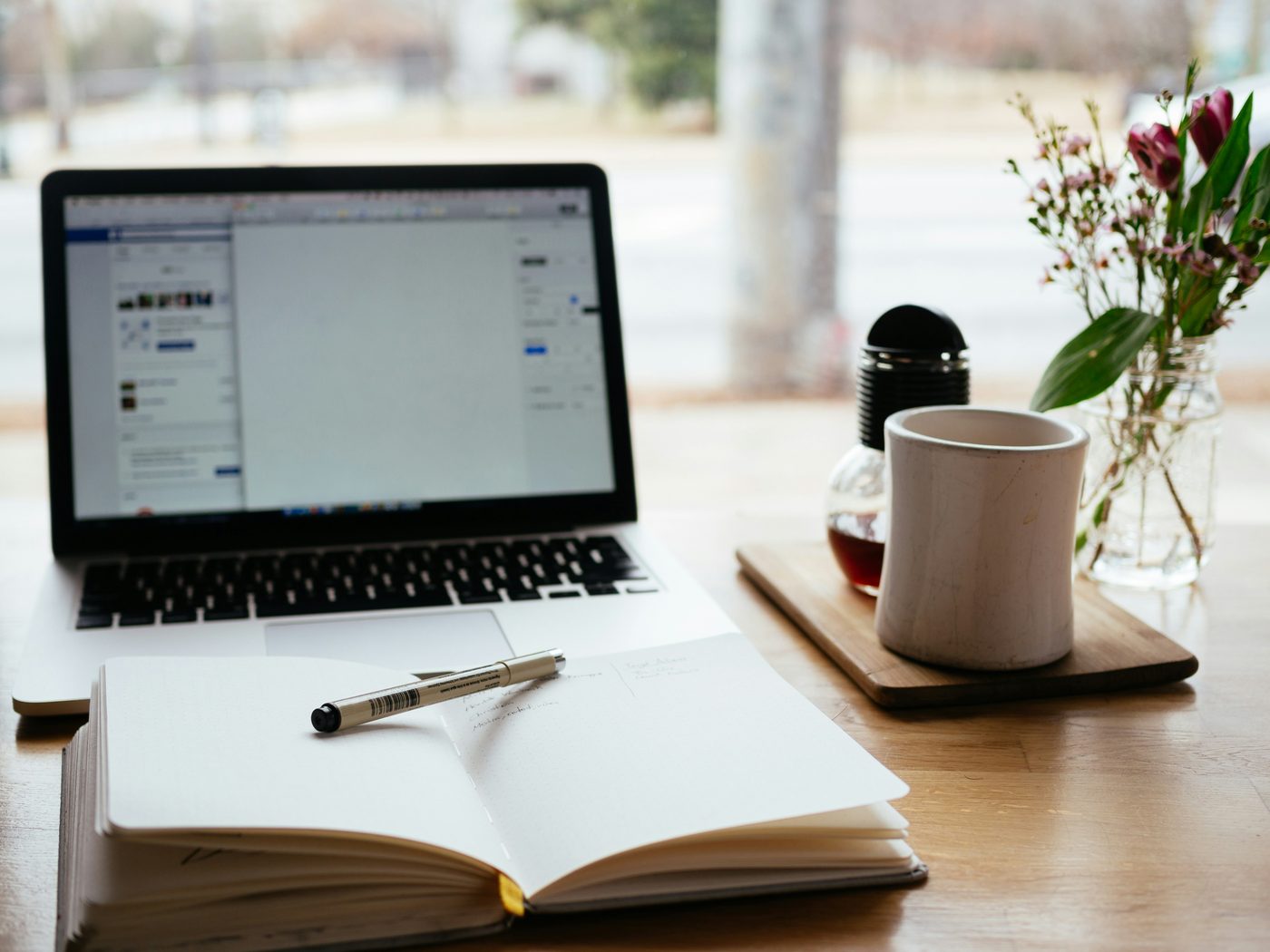 Bureau avec ordinateur portable, carnet et tasse de café