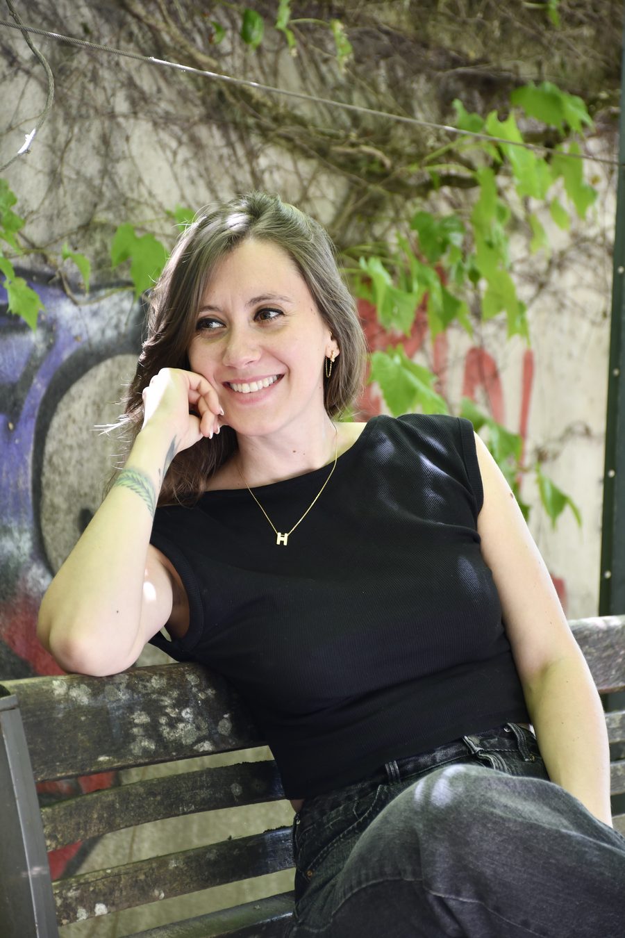 Portrait d'Anne-Sophie, souriante, assise sur un banc